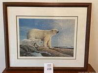 Full view of the framed print showing the polar bear family with matting and wooden frame.