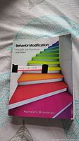 Front cover of Behavior Modification textbook showing colorful stair-step design and author name.