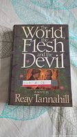 Front cover of hardcover book 'The World The Flesh and the Devil' by Reay Tannahill showing title and author with a small illustrated image.