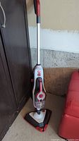Full view of upright Hoover Steam Complete Pet steam mop showing the handle, body with buttons, and triangular mop head.
