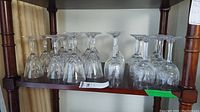 Shelf display of 17 crystal stemware glasses of three distinct styles.