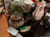 Setup of various kettles, teapots, coffee pots, and pitchers showing details and arrangement