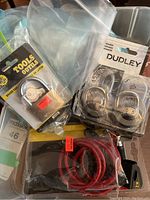 Photo showing brass pad lock in packaging labeled 'Tools Outlet' plus two Dudley combination locks and red cable lock.