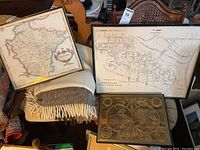 Three framed maps displayed together showing the Rosedale residential map, Devonshire England map, and the gold foil world map.