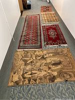 Photo showing all five rugs laid out in a hallway, displaying different sizes, colors, and patterns including the tapestry style and runner.