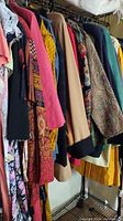 Photo showing assorted women's jackets and dresses on a rack, various colors and patterns