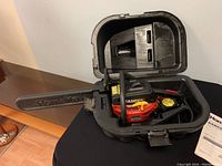 Homelite Ranger 16 inch chainsaw inside original fitted hard plastic carrying case on black surface.