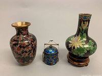 Three old Chinese cloisonné enamel pieces displayed together: two vases and one miniature treasure box.