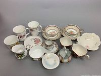 Overhead view of assorted vintage chinaware including cups, bowls, saucers, and plates arranged together showing patterns and shapes