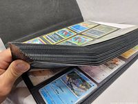Photo showing thick binder with multiple plastic pages filled with Pokémon cards.