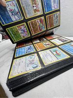 Side view of the thick binder filled with plastic sleeves holding Pokémon cards with visible card artwork and borders.