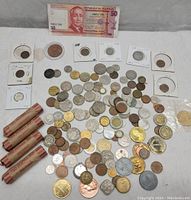 Wide view of mixed coins, four penny rolls and Philippine banknote