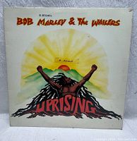 Front cover of Bob Marley & The Wailers Uprising LP album featuring an illustrated figure with raised fists against a sun and mountain background.