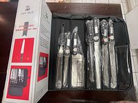 Box and opened zippered carrying case showing wrapped knives and utensils organized inside the case.