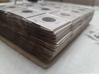 Side view showing thick binder packed with plastic coin holders containing copper pennies