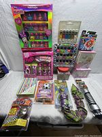 Wide view showing all items laid out against a white background including boxes of nail polish, craft paint tubes, toy snake, and other small toys.