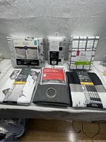 Overview of bed sheets, curtains, and shower curtain packaged and displayed on a surface.