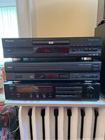 Stacked units showing Pioneer DVD player on top, RCA 5-disc CD changer in middle, Rotel receiver on bottom.