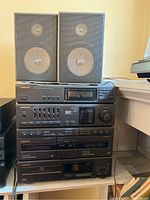 Front view of the stacked Samsung stereo music system and two bookshelf speakers showing all components and speaker drivers.