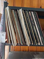 Side view of over 30 classical LP albums and boxed sets showing worn and damaged covers.