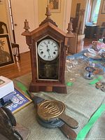 Side and front view of the wooden mantle clock with the bellows placed in front.