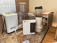 Initial photo showing all kitchen appliances including the Braun food processor, two GS Iona electric coffee grinders, blender, and analog food scale on countertop.