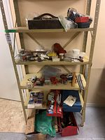 Full shelf of assorted tools, hardware, small tool cases, and a propane torch kit