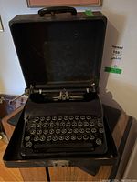 Front view of the vintage Corona portable typewriter inside its open case, showing the keyboard and case interior.