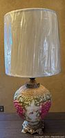 Full view of lamp with white shade covered in protective plastic wrap, showing overall height and condition.