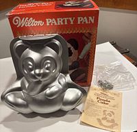 Aluminum 3D panda bear cake pan with original orange Wilton Party Pan box, instruction sheet, and metal supports.