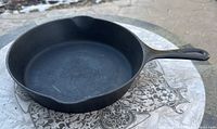 Side angle view of the vintage Wagner size 7 cast iron skillet showing handle, pouring spout, and cooking surface.