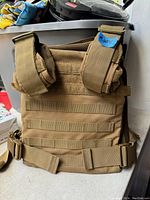 Tan adjustable weight vest laid flat showing front and strap details