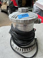 Front view of the Polygroupe pool pump showing top cover and cord wrapped around base