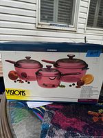 Original box showing three pink translucent glass-ceramic pots with lids
