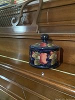Front side view of covered dish and lid showing hand-painted fruit motif