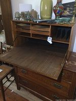 Front view of the desk top secretary with drop front open showing interior small drawers and slots for papers.