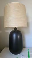 Full front view of table lamp showing ceramic base and jute resin shade