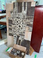 Full view of standing board with attached tiles and box of loose tiles at base