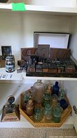 Overview showing ink jar, brass and decorative inkwells, printer blocks, and tray of bottles