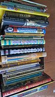 Photo showing a stack of children's and young adult books including puzzle books, Lego, Diary of a Wimpy Kid, Beverly Cleary, and Scooby Doo titles.