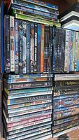 DVD cases stacked and lined up showing titles mostly in children's and family genres including Stuart Little and animated feature films.
