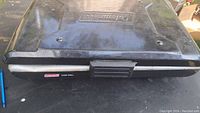 Closed Coleman portable camp grill with black top casing and central latch.
