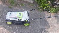 Side and top view of the LawnMaster electric lawn mower showing yellow-green color accents on wheels and handle.