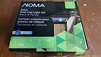 Box front showing NOMA branding, product name, and features including 8 lights, cool white LED, solar power usage.