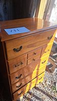 Photo of pine high boy dresser with six large drawers and two smaller drawers. One drawer handle is missing.