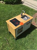 Full view of wooden toy kitchen set showing stove, oven, and sink