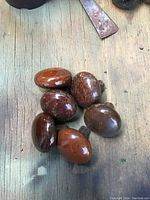Set of six vintage oval mineral Bennington stoneware doorknobs with smooth brown gloss finish, shown top view on rustic wood surface.