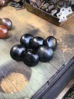 Top view showing six black stoneware doorknobs grouped together, showing their round, glossy surfaces.