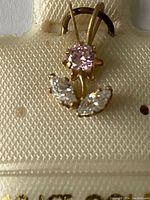 Close-up photo of the 10Kt yellow gold pendant showing pink round CZ center stone and two clear marquise CZ stones.