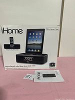 Front view of original iHome stereo clock radio box with product image, text, and an iHome remote control laid in front